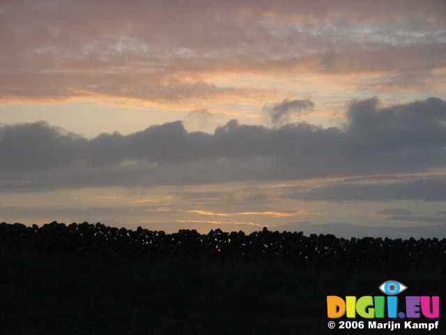 19207 Sunset through stone wall